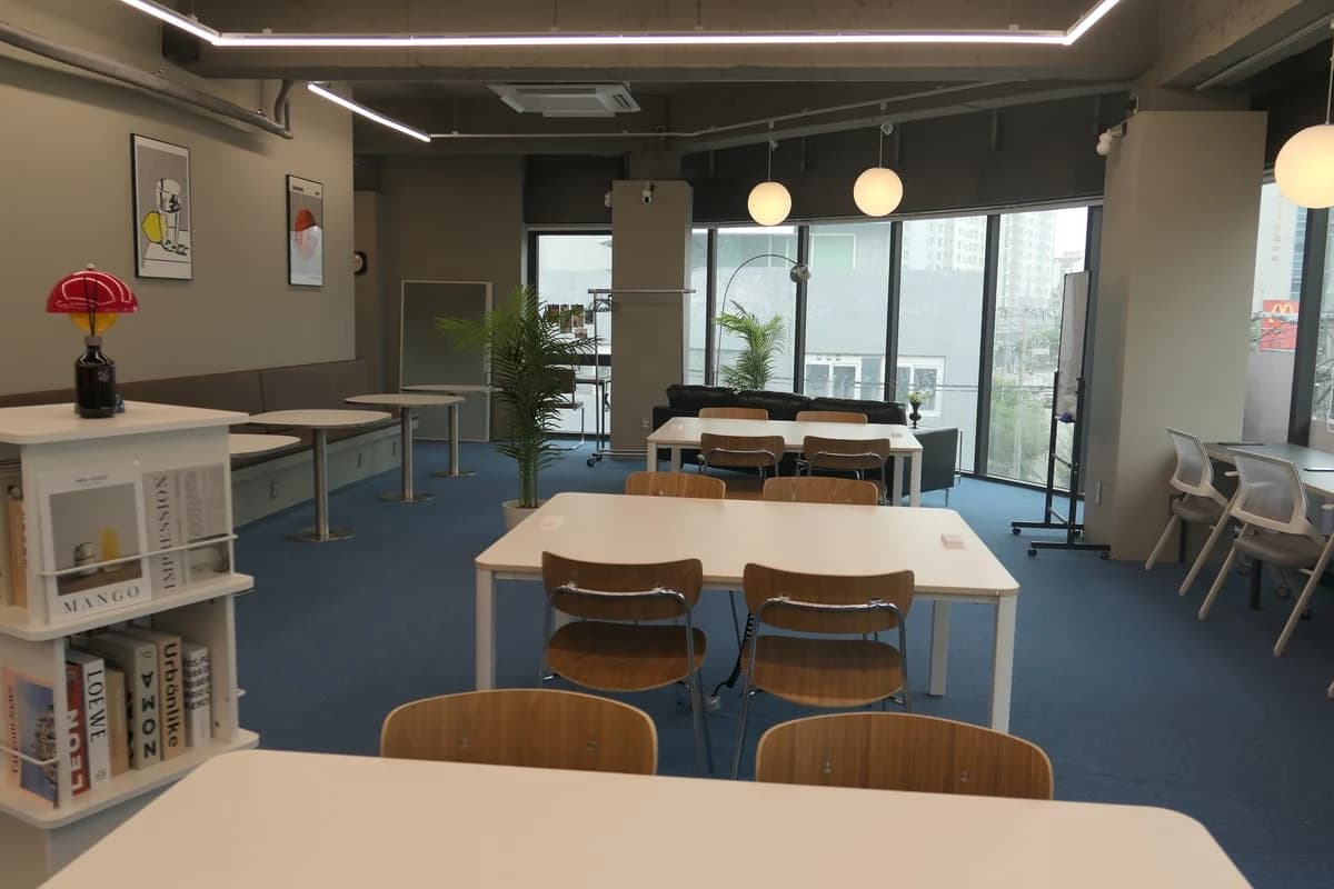작당워크라운지 화곡점 라운지 — 펜던트 조명 아래 테이블과 통창